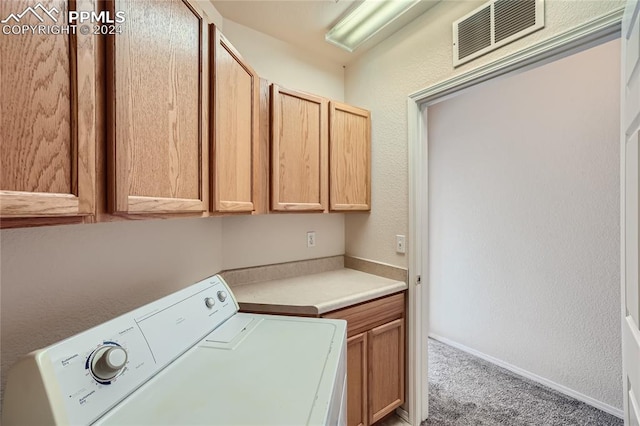 laundry room with carpet flooring, cabinets, and washer / clothes dryer