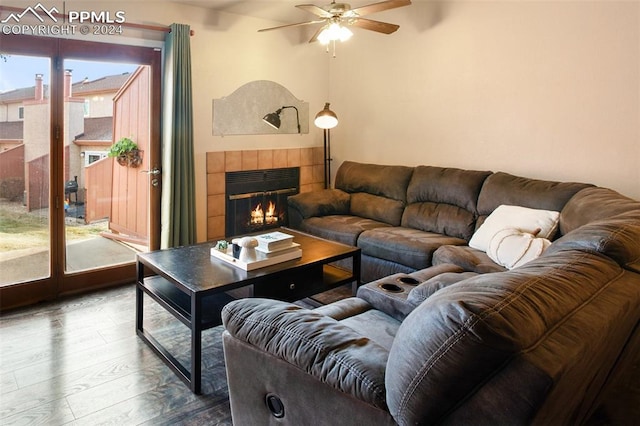 living room featuring ceiling fan, dark hardwood / wood-style flooring, and a fireplace