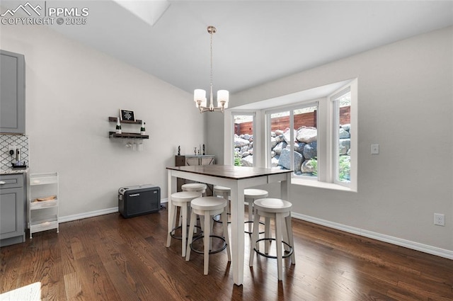 dining area featuring dark hardwood / wood-style flooring and a notable chandelier