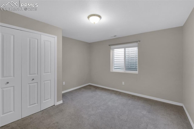 unfurnished bedroom featuring light carpet and a closet