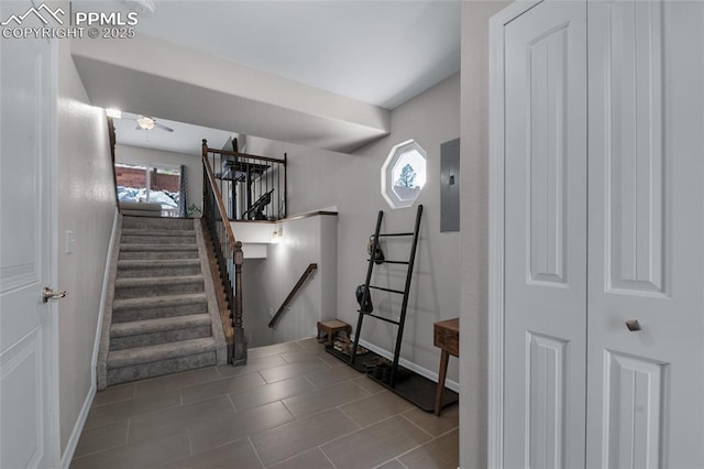 stairs with tile patterned flooring, electric panel, and a healthy amount of sunlight