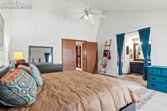 bedroom with high vaulted ceiling, ceiling fan, and connected bathroom