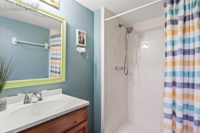 bathroom with a shower with shower curtain and vanity