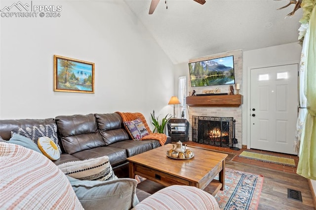 living room with a brick fireplace, ceiling fan, wood-type flooring, and vaulted ceiling