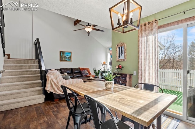 dining space with ceiling fan with notable chandelier, a textured ceiling, dark hardwood / wood-style floors, and vaulted ceiling