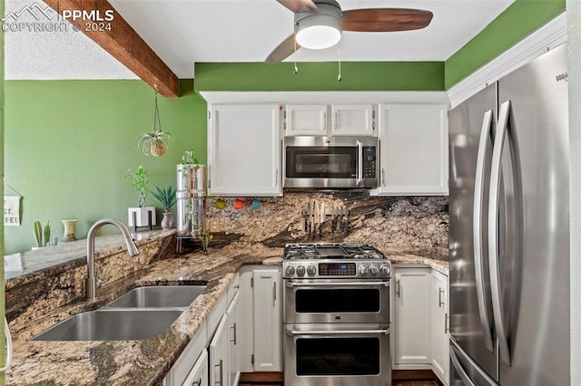 kitchen with dark stone countertops, white cabinetry, sink, and appliances with stainless steel finishes