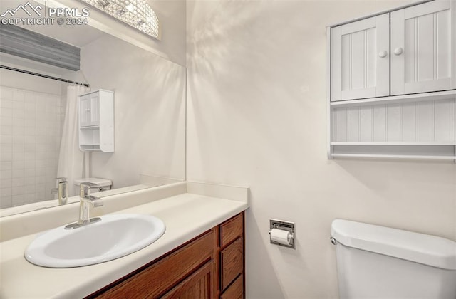 bathroom featuring vanity, toilet, and walk in shower