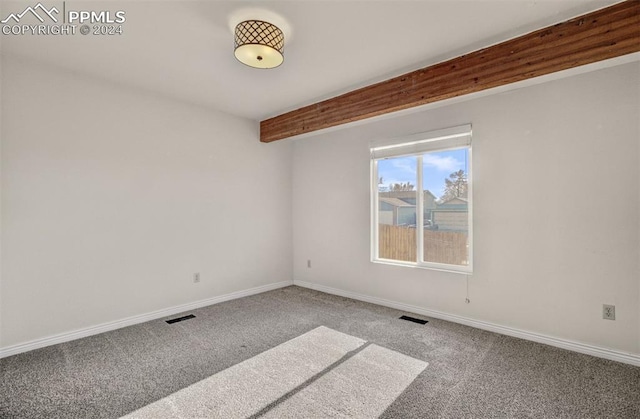 spare room with beamed ceiling and carpet floors