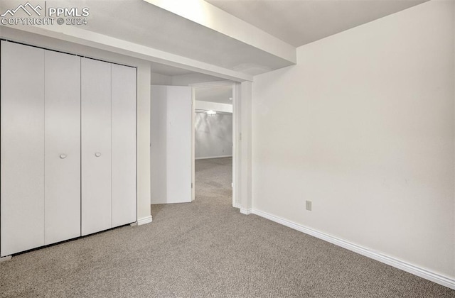 unfurnished bedroom with light carpet and a closet