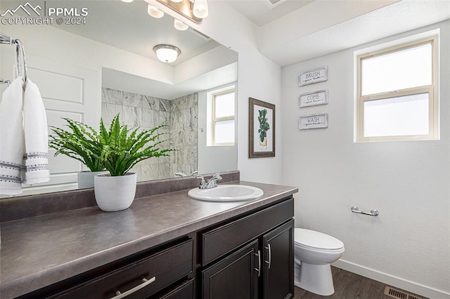 bathroom with hardwood / wood-style floors, vanity, and toilet