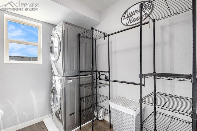 washroom with dark hardwood / wood-style flooring and stacked washing maching and dryer