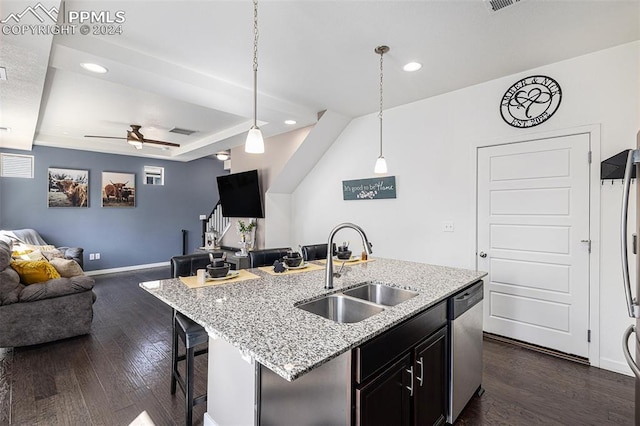 kitchen featuring stainless steel dishwasher, ceiling fan, sink, decorative light fixtures, and an island with sink