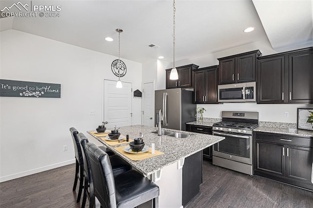 kitchen featuring sink, stainless steel appliances, pendant lighting, a breakfast bar area, and a kitchen island with sink