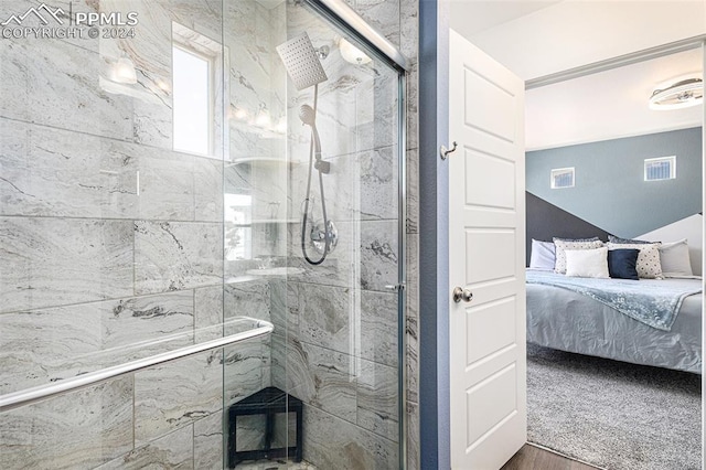 bathroom with an enclosed shower and wood-type flooring