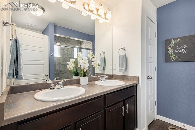 bathroom featuring wood-type flooring, vanity, and walk in shower