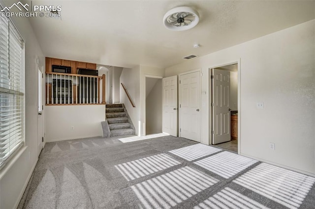 interior space with ceiling fan and light carpet