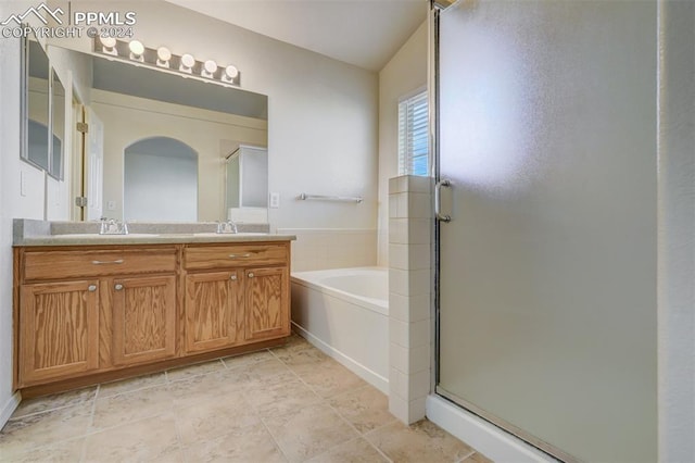 bathroom featuring vanity and independent shower and bath