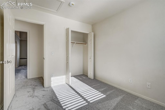 unfurnished bedroom with light carpet and a closet