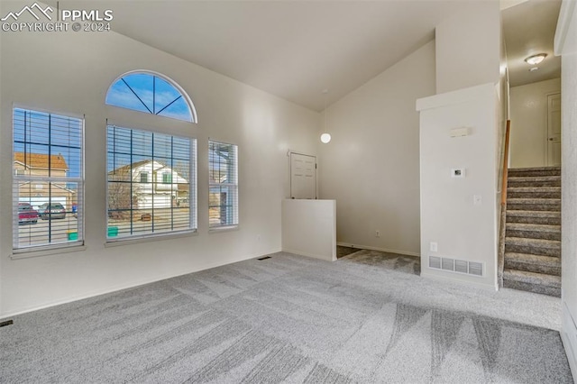 interior space featuring light carpet and high vaulted ceiling