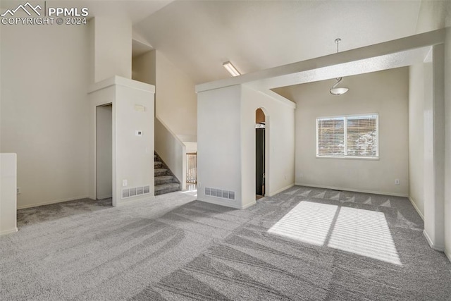 interior space featuring light colored carpet and high vaulted ceiling