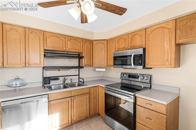 kitchen featuring ceiling fan, sink, light tile patterned floors, and stainless steel appliances