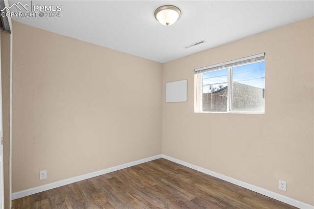 spare room with dark hardwood / wood-style floors