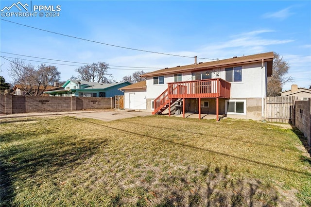 back of house featuring a lawn, a patio area, and a deck