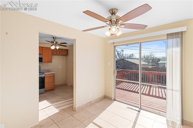 spare room with ceiling fan and light tile patterned floors