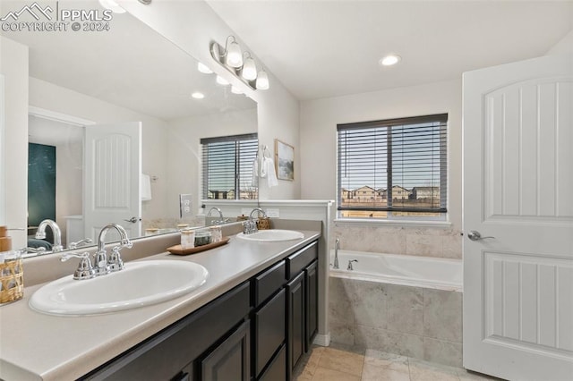 bathroom featuring vanity and tiled bath