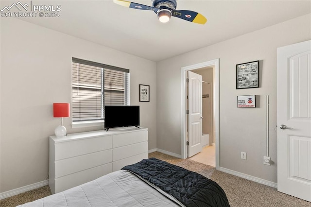 bedroom featuring ensuite bath, light colored carpet, and ceiling fan