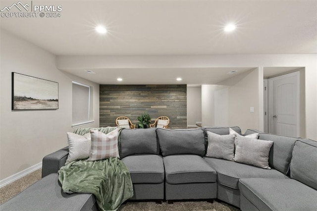 carpeted living room with wood walls