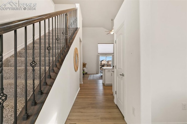 stairs with lofted ceiling and hardwood / wood-style floors