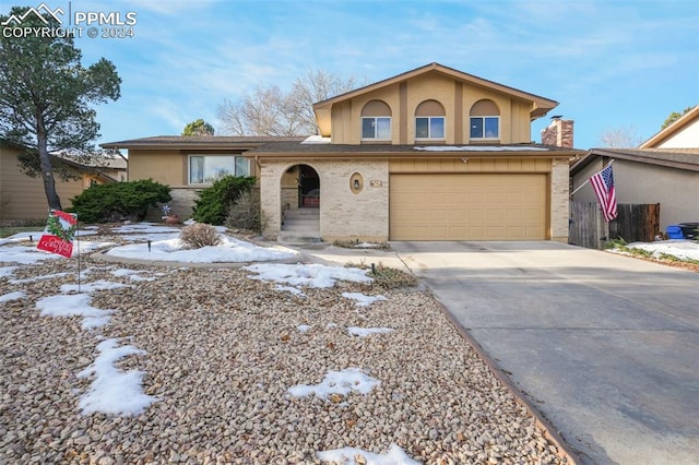 view of front facade with a garage, brick siding, driveway, and stucco siding