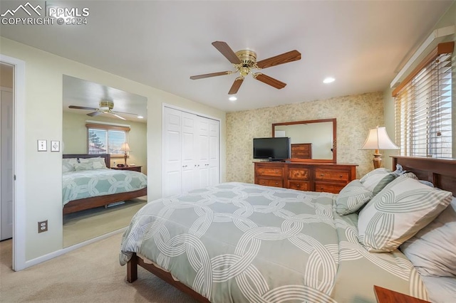 bedroom featuring a closet, light colored carpet, ceiling fan, baseboards, and wallpapered walls