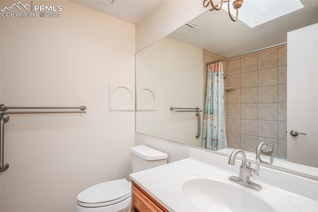 bathroom with a skylight, a shower with shower curtain, vanity, and toilet