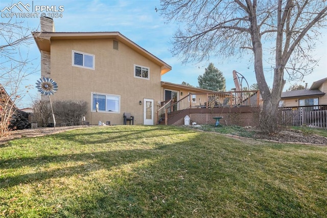 back of property featuring a yard, stairs, a deck, and stucco siding