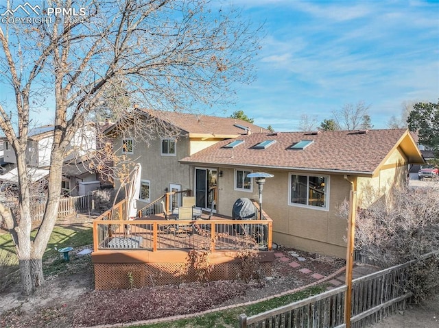 back of property featuring fence, a deck, and stucco siding