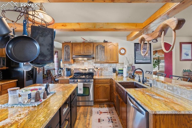 kitchen featuring beamed ceiling, appliances with stainless steel finishes, tasteful backsplash, and light stone countertops