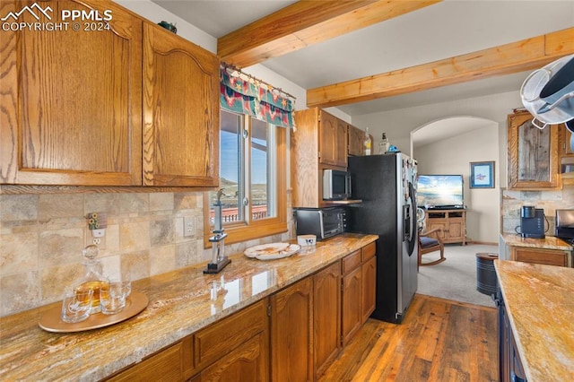 kitchen with light stone counters, appliances with stainless steel finishes, tasteful backsplash, beam ceiling, and dark hardwood / wood-style flooring