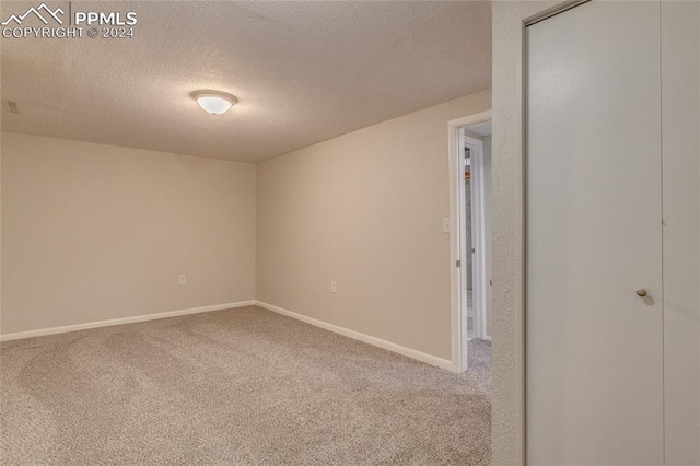 spare room featuring carpet flooring and a textured ceiling