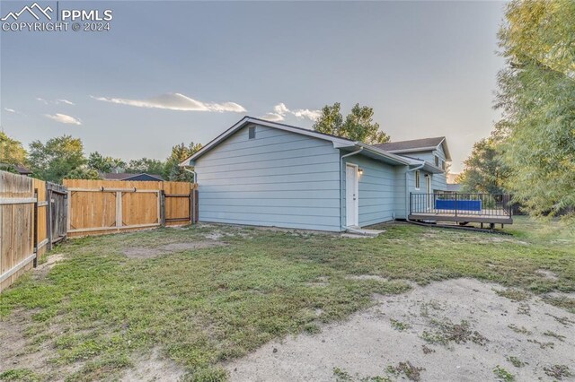 rear view of house featuring a yard and a wooden deck