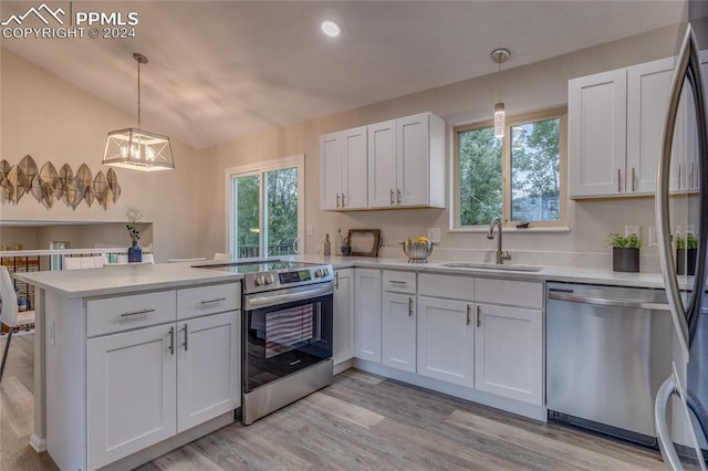 kitchen featuring kitchen peninsula, appliances with stainless steel finishes, sink, white cabinets, and hanging light fixtures