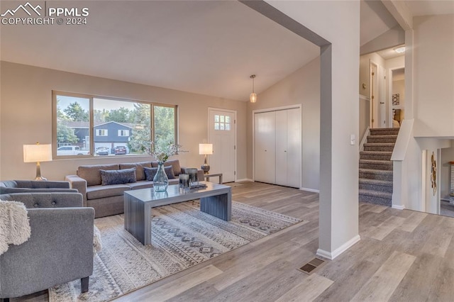 living room featuring light hardwood / wood-style flooring and vaulted ceiling