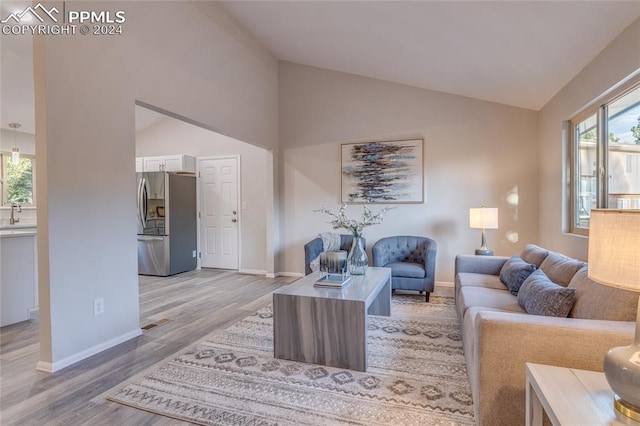 living room with light hardwood / wood-style flooring and lofted ceiling