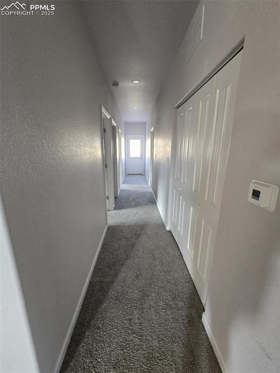 hall featuring dark carpet