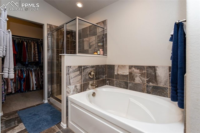 bathroom featuring tile patterned flooring and shower with separate bathtub