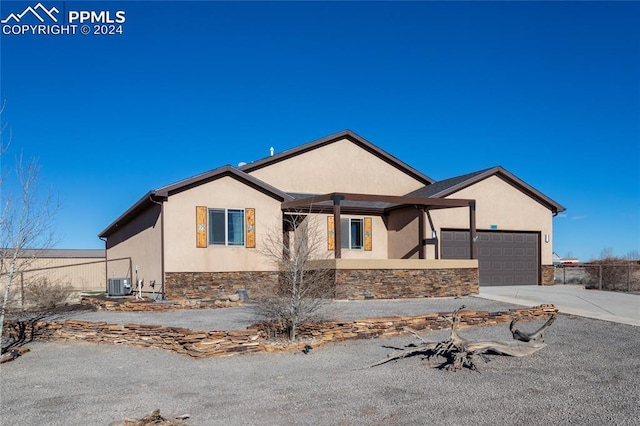 view of front of property featuring a garage and central AC