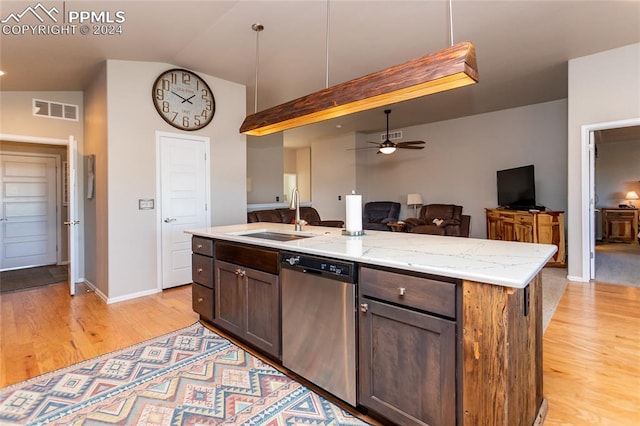 kitchen with sink, stainless steel dishwasher, ceiling fan, an island with sink, and light stone counters