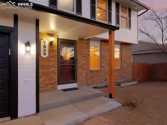 exterior entry at dusk featuring a porch