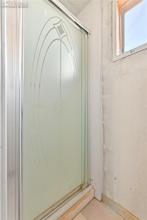 bathroom with a shower with door